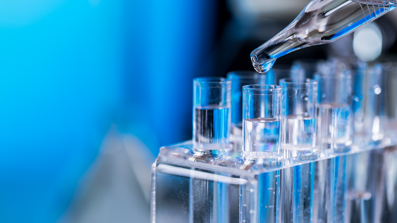 FDA 공정 검증을 수행하기 위해 시험관과 피펫을 사용하여 투명한 액체 치료제를 실험하고 있음.